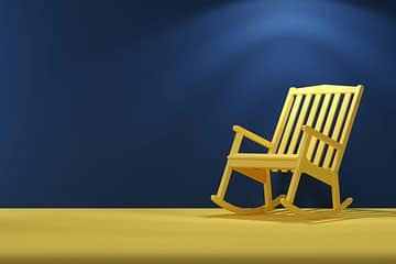 a wooden rocking chair sitting on top of a yellow floor